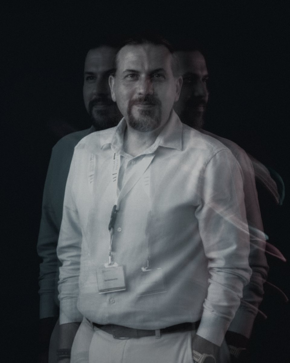 Waist-up portrait of Christos Chiotis, black and white, against a dark background